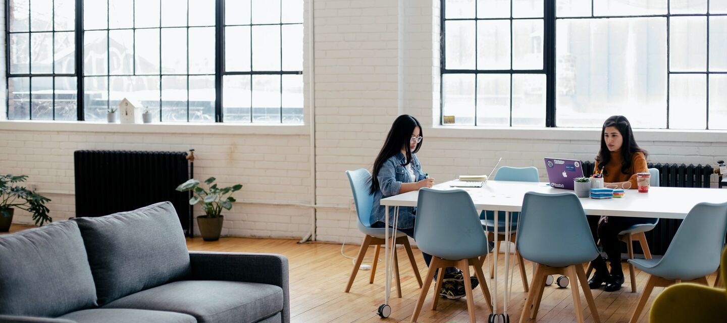 Kolleginnen arbeiten im stilvollen Großraumbüro